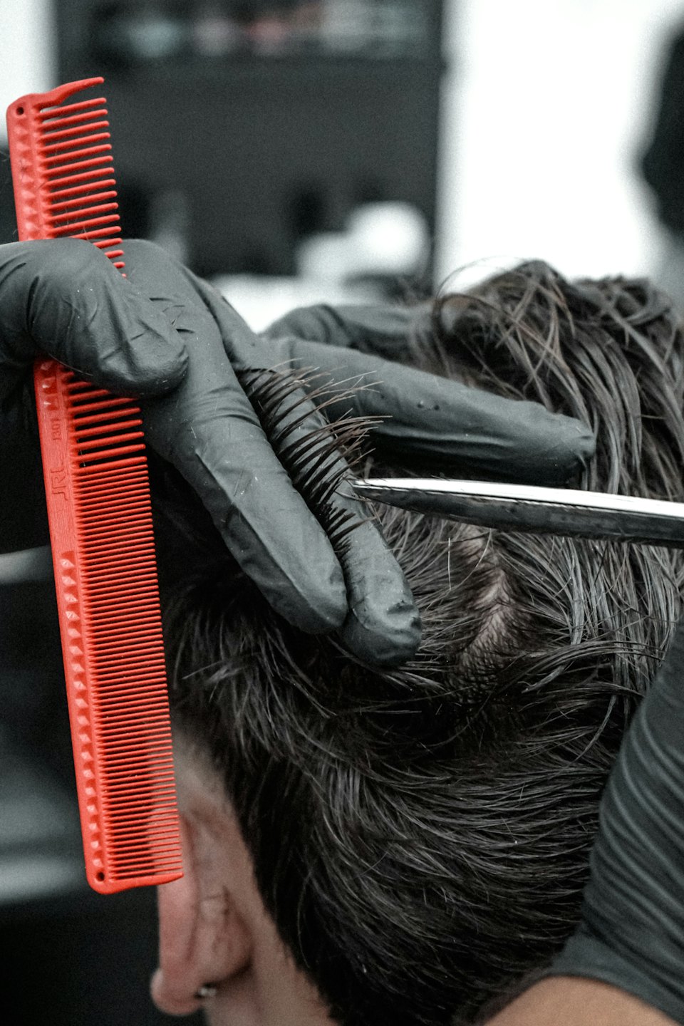 Stylist using scissors and a comb to trim hair.